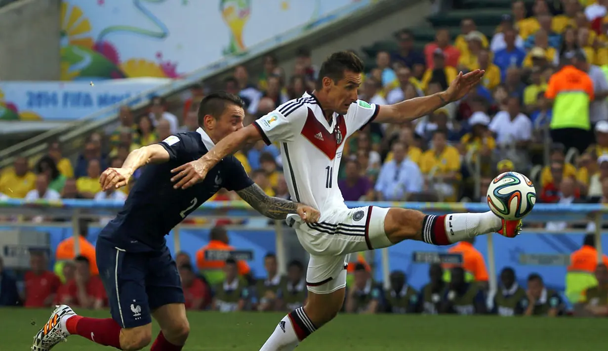 Pemain belakang Timnas Perancis, Mathieu Debuchy (kiri) berusaha menahan laju penyerang Jerman, Miroslav Klose saat berlaga di perempat final Piala Dunia 2014 di Stadion Maracana, Rio de Janeiro, (4/7/2014). (REUTERS/Pilar Olivares)