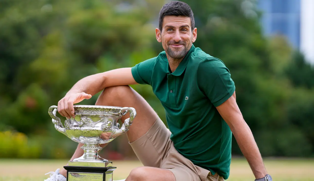 Petenis Serbia Novak Djokovic berpose dengan Norman Brookes Challenge Cup usai menjuarai Australian Open 2023 di Taman Government House, Melbourne, Australia, 30 Januari 2023. Djokovic sempat mengalami cedera hamstring yang mengganggunya selama tahap awal turnamen Australian Open 2023. (AP Photo/Ng Han Guan)
