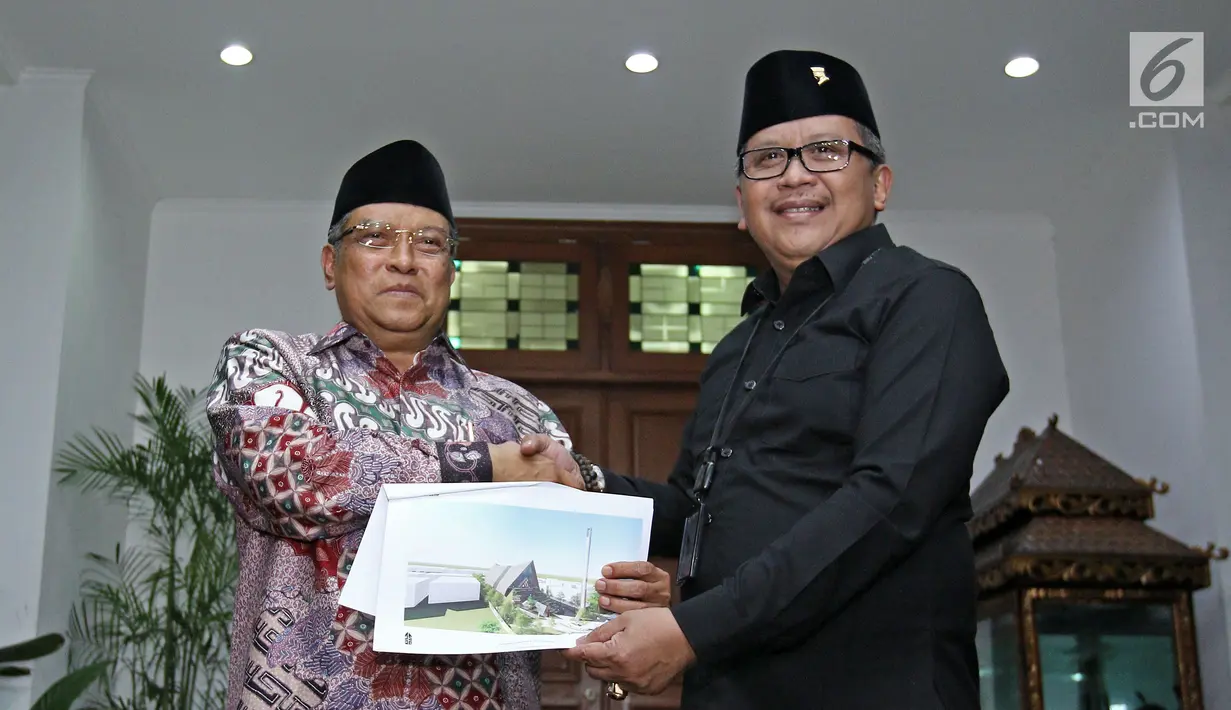 Ketua Umum PBNU Said Aqil Siradj (kiri) dan Sekjen PDI Perjuangan Hasto Kristiyanto (kanan) berjabat tangan dan menunjukkan rencana gambar pembangunan masjid di Lenteng Agung, di Jalan Teuku Umar, Jakarta, Sabtu (14/10). (Liputan6.com/Herman Zakharia)