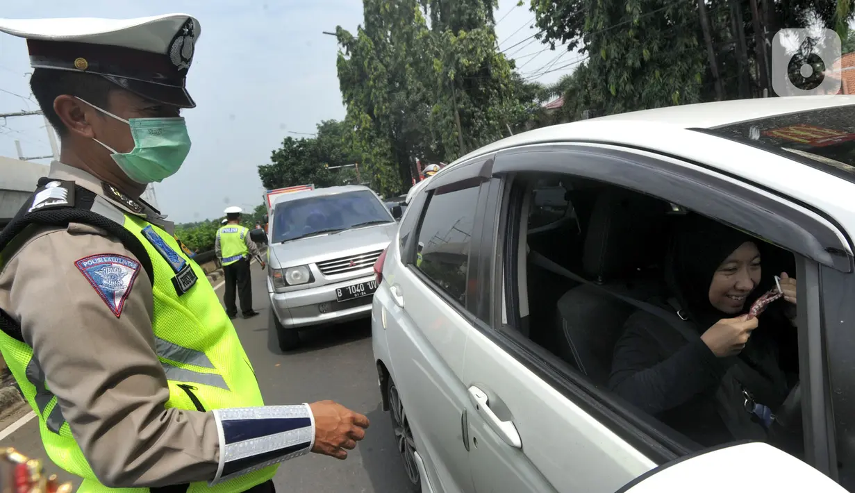 Petugas menyuruh pengemudi mengenakan masker saat kegiatan Check Point Pengawasan Pelaksaanaan PSPBB di kawasan Pasar Jumat, Jakarta selatan, Jumat (10/4/2020). Kegiatan gabungan Dishub dan Polda Metro Jaya merupakan Pergub Nomor 33 Tahun 2020 tentang Pelaksanaan PPSB. (merdeka.com/Arie Basuki)