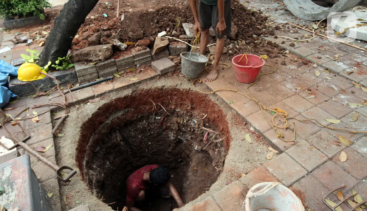 Pekerja saat membuat lubang untuk sumur rasapan di Jalan Kebon Jeruk, Jakarta Barat, Jumat (15/10/2021). Pemda DKI Jakarta menargetkan pembuatan 22.292 titik sumur resapan atau drainase vertikal sebelum memasuki puncak musim penghujan pada awal Januari.  (Liputan6.com/Johan Tallo)
