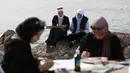 Lokakarya Bernapas dan Melukis menjadikan seni sebagai bentuk perlawanan dan sarana bertahan hidup di tengah krisis akibat perang. Tampak dalam foto, Para perempuan muda melukis di pelabuhan Kota Gaza pada Kamis 12 Februari 2026. (Omar AL-QATTAA/AFP)