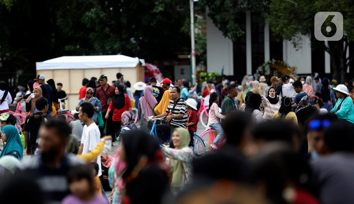 Pengunjung Kota Tua tetap jaga protokol kesehatan dengan memakai masker dan jaga jarak.  (Liputan6.com/Johan Tallo)