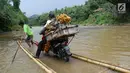 Pengendara roda dua memanfaatkan jasa perahu rakit untuk menyeberangi Sungai Cisadane di Rumpin, Bogor, Selasa (13/3). Akibat rusaknya jembatan akses  utama Rumpin-Ciseeng, warga menaiki perahu rakit dengan tarif Rp10.000. (Liputan6.com/Achmad Sudarno)