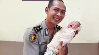 Bayi dibuang orang tuanya ditimang polisi yang bertugas di RS Bhayangkara Pekanbaru. (Liputan6.com/M Syukur)