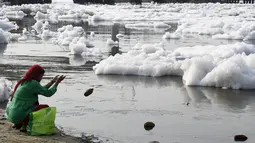 Seorang wanita berdoa di Sungai Yamuna yang tercemar di New Delhi, Sabtu (8/7). Pada 1909, air sungai ini tergolong sebagai "biru jernih" bila dibandingkan dengan Sungai Gangga yang berwarna kuning kecoklatan. (DOMINIQUE FAGET / AFP)