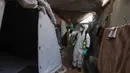 Seorang pengungsi Palestina menyemprotkan cairan disinfektan pada jalan setapak dan tenda-tenda untuk membasmi serangga dan hewan pengerat di kamp pengungsian Khan Yunis, Jalur Gaza Selatan pada Rabu 22 April 2026. Krisis kemanusiaan di Gaza kian memburuk. (Bashar Taleb/AFP)