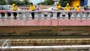 Sejumlah pekerja melakukan pengecatan Jembatan Merah di Jalan Pangeran Jayakarta, Jakarta, Selasa (27/12). Pengecatan dilakukan untuk memperindah jembatan agar terlihat bersih dan terawat. (Liputan6.com/Gempur M. Surya)