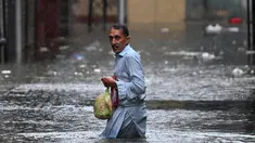 Seorang pria menyeberangi jalan yang tergenang air saat hujan monsun lebat di Rawalpindi, Pakistan, pada 17 Juli 2025. (Aamir Qureshi/AFP)