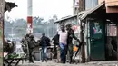 Petugas keamanan Kenya membawa seorang pria usai terjadi pembunuhan saat kericuhan perkampungan Mathare di Nairobi, Kenya (9/8). (AFP Photo/Marco Longari)