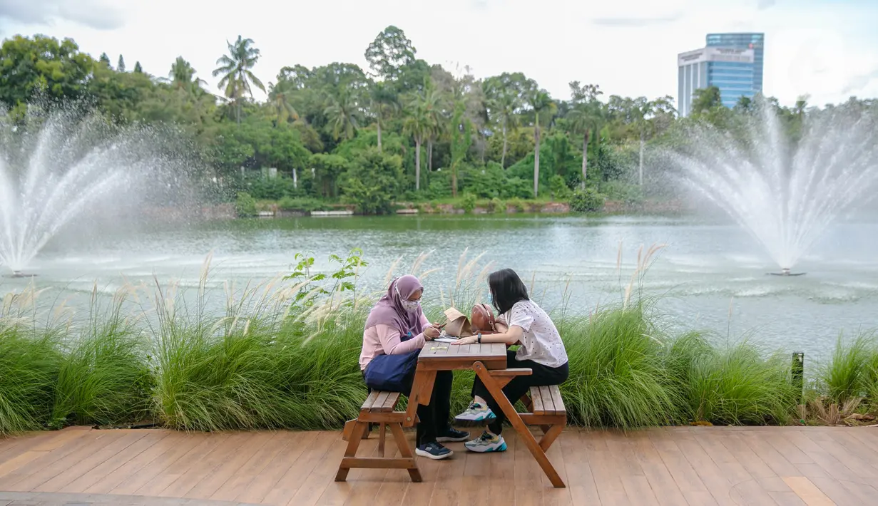Wisatawan duduk saat mengunjungi Senayan Park, Jakarta, Rabu (9/12/2020). Libur Nasional Pilkada Serentak 2020 dimanfaatkan sebagian warga Jakarta dan sekitarnya untuk mengunjungi tempat rekreasi bersama keluarga. (Liputan6.com/Faizal Fanani)