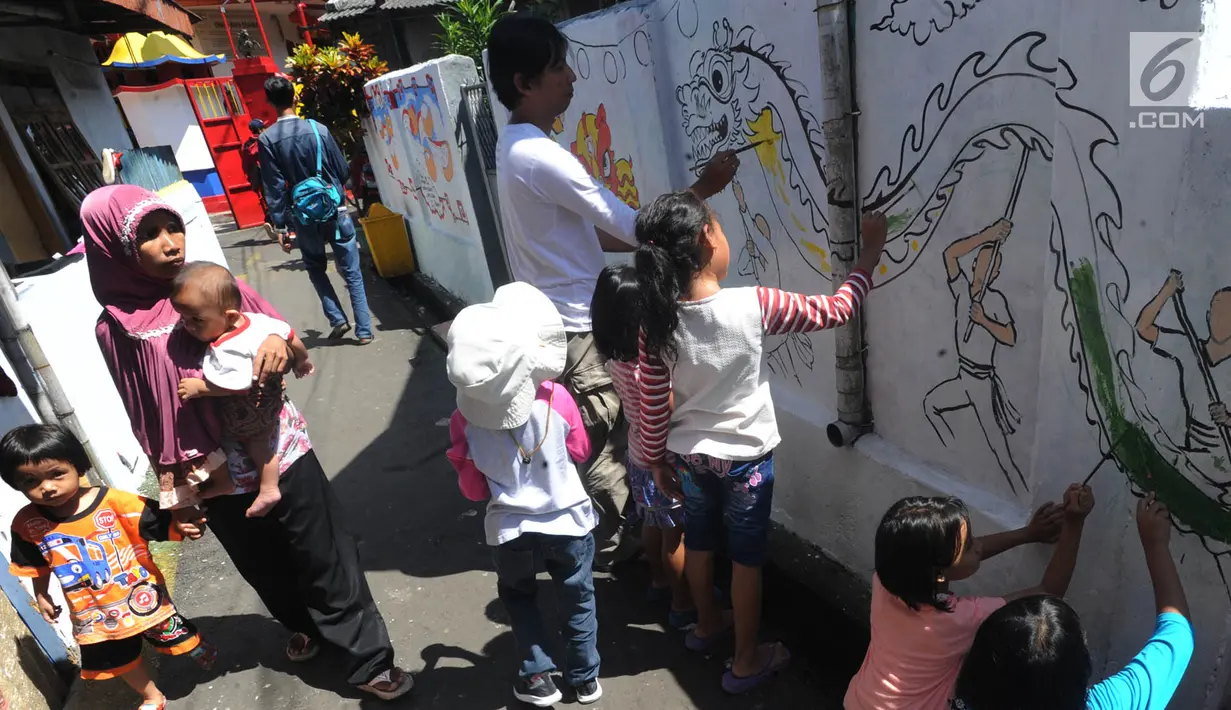 Pejalan kaki melintas dekat sejumlah anak yang melukis mural pada dinding areal gang sempit di Pulo Gelis, Bogor, Minggu (18/3). Kegiatan ini untuk menjadikan Kampung Pulo Geulis sebagai salah satu tujuan wisata baru di Bogor. (Merdeka.com/Arie Basuki)