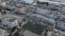 Foto udara menunjukkan kehancuran di pusat kota Hatay, Turki selatan, Selasa (7/2/2023). Karena banyaknya gempa susulan, banyak warga di wilayah terdampak yang tak bisa berlindung di rumah dan memilih berada di mobil bersama anak-anaknya.  (IHA via AP)