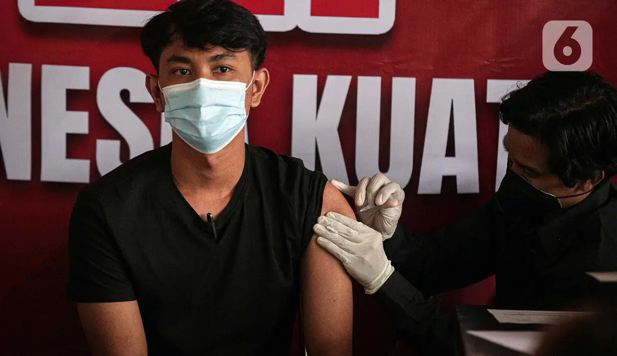 Petugas kesehatan menyuntikkan vaksin booster COVID-19 kepada seorang pria di Pasar Tanah Abang Blok A, Jakarta, Senin (4/4/2022). Vaksinasi yang diselenggarakan Polri ini diikuti warga sekitar dan pedagang Pasar Tanah Abang yang berencana mudik Lebaran. (Liputan6.com/Faizal Fanani)