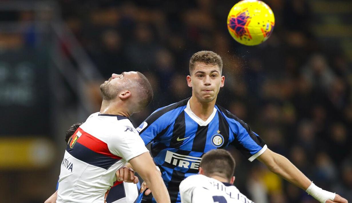 Pemain Inter Milan, Sebastiano Esposito, duel udara dengan pemain Genoa, Davide Biraschi, pada laga Serie A 2019 di Stadion San Siro, Sabtu (21/12). Inter Milan menang 4-0 atas Genoa. (AP/Luca Bruno)