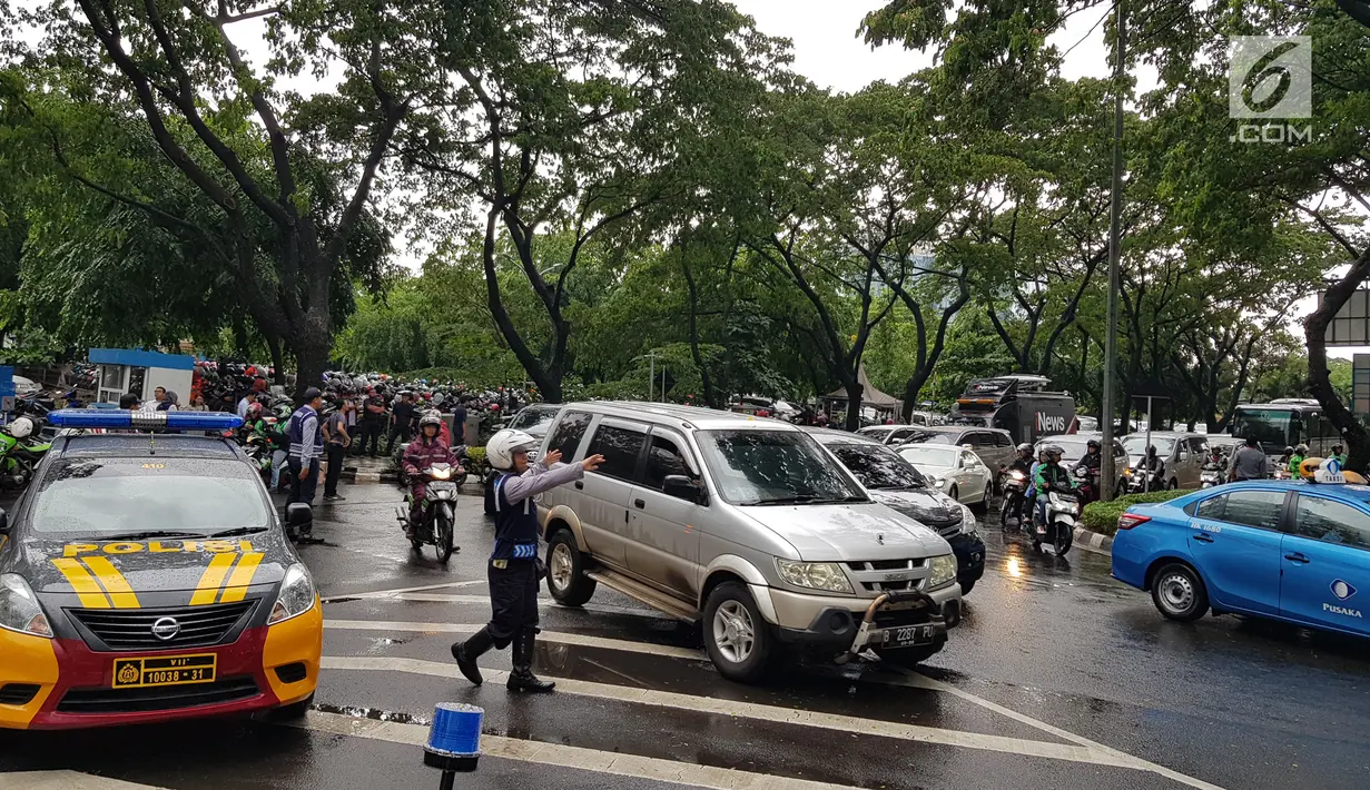 Petugas mengarahkan kendaraan yang melintasi kawasan SCBD usai balkon BEI ambruk, Jakarta, Senin (15/1). Ambruknya atap lobi balkon Bursa Efek Indonesia (BEI) membuat lalu lintas di sekitar SCBD macet. (Liputan6.com/Herman Zakharia)