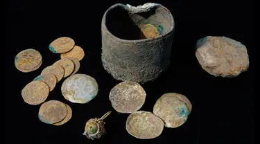 Koin emas kuno dan anting-anting yang ditemukan di sebuah situs penggalian di kota Mediterania Kaisarea, Israel, Senin (3/12). 24 keping koin dan anting-anting emas yang ditemukan dalam sebuah bejana perunggu itu berusia sekitar 900 tahun. (JACK GUEZ/AFP)