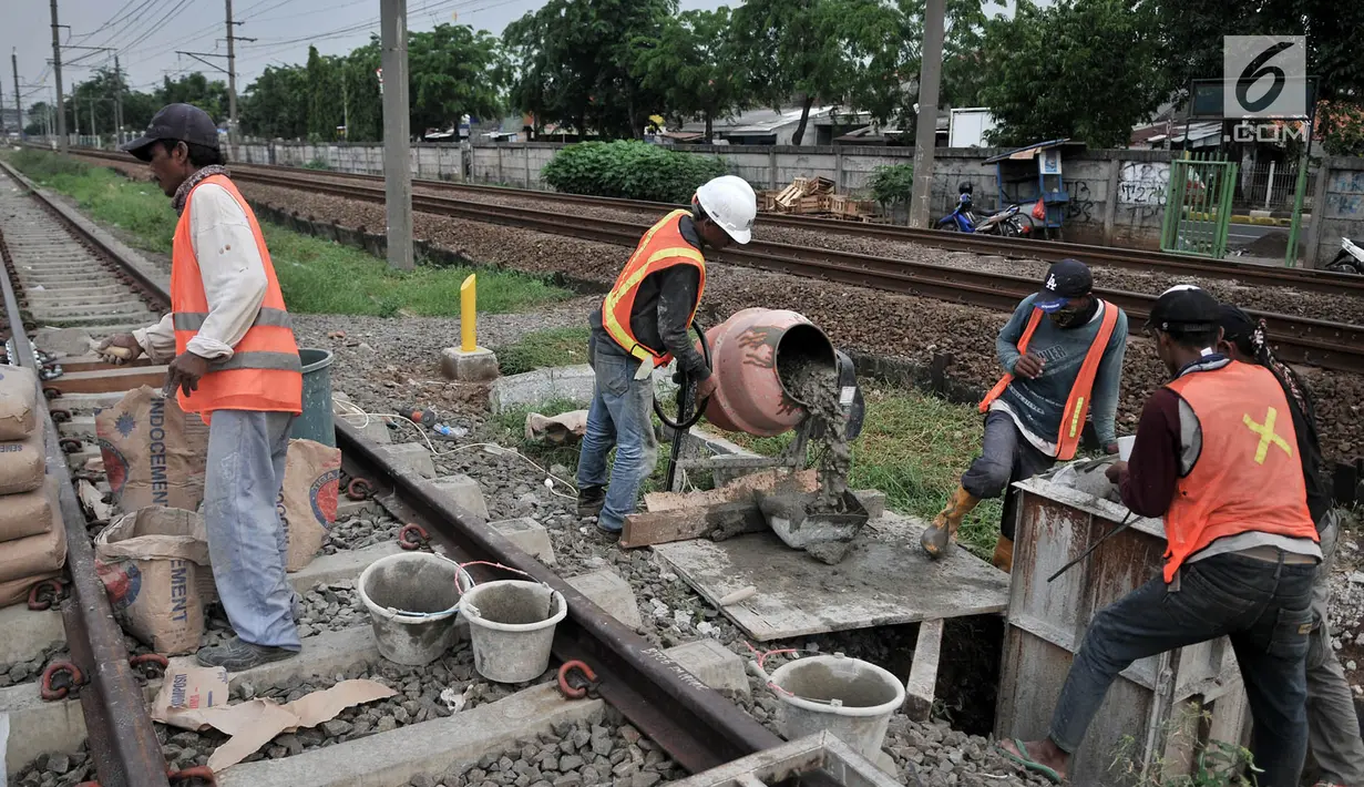 Pekerja menyelesaikan pondasi tiang sinyal elektrik jalur DDT Manggarai-Cikarang, Jakarta, Selasa (13/11). Pemasangan sistem persinyalan untuk Paket B1 DDT yang memiliki panjang lintasan 34 kilometer. (Merdeka.com/Iqbal S. Nugroho)