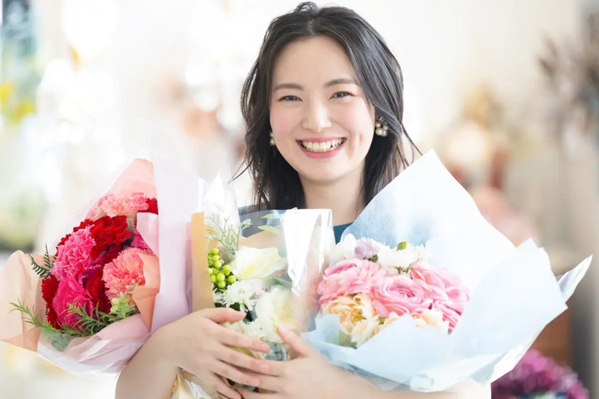 perempuan cantik tertawa membawa bunga