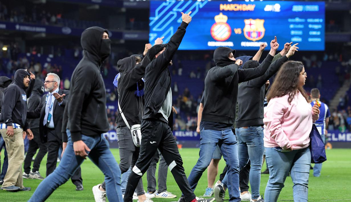 Namun, suporter dari tribun selatan Espanyol merangsek masuk lapangan, yang menyebabkan para pemain dan staf pelatih Barcelona berlari ke terowongan. (AFP/Lluis Gene)