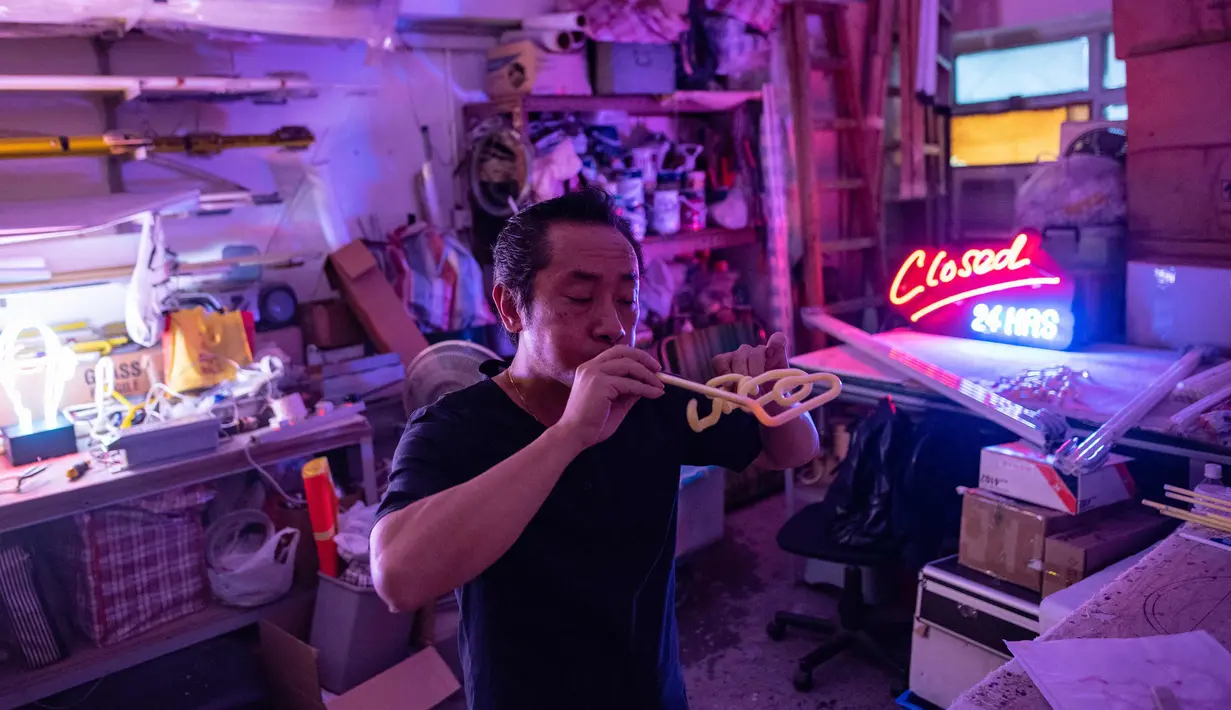 Wu Chi-kai mendemonstrasikan bagaimana membuat neon sign selama wawancara dengan AFP di Hong Kong (16/4). Wu Chi-kai merupakan salah satu pengrajin neon sign yang tersisa dari jenisnya di Hong Kong. (AFP Photo/Philip Fong)