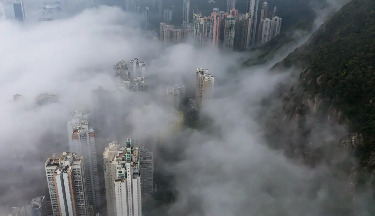 Kabut di atas Hong Kong, Selasa (22/3/2022). Kabut tebal menyelimuti Hong Kong pada musim semi ketika wilayah tersebut dipengaruhi oleh udara dingin dan hangat bergantian. (AFP/Dale De La Rey)