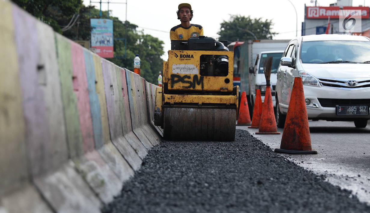 Petugas Bina Marga Pasar Minggu menambal jalan yang rusak di Jalan Raya Ragunan, Jakarta, Senin (22/4). Petugas mengaku bahwa keberadaan beton pembatas jalan justru membuat jalan di kawasan tersebut selalu rusak setiap hujan deras karena menimbulkan genangan air. (Liputan6.com/Immanuel Antonius)