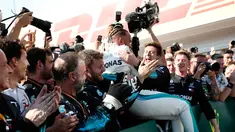 Pembalap Mercedes, Lewis Hamilton berselebrasi bersama timnya saat merayakan keberhasilnnya menjuarai GP Hungaria di Sirkuit Hungaroring, Mogyorod, (29/7). Hamilton berhasil menjuarai secara beruntun di musim ini. (AP Photo/Laszlo Balogh)