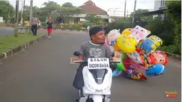 Setelah mencoba jualan makanan, Ucok Baba juga mencoba berjualan balon keliling. Balon yang terdiri dari berbagai bentuk karakter kartun itu memang disukai oleh anak-anak. Biasanya dijajakan dengan menggunakan sepeda, tapi kali ini pria 51 tahun itu berkeliling dengan menggunakan motor kecilnya. (Liputan6.com/YouTube/@UcokBabaofficial)