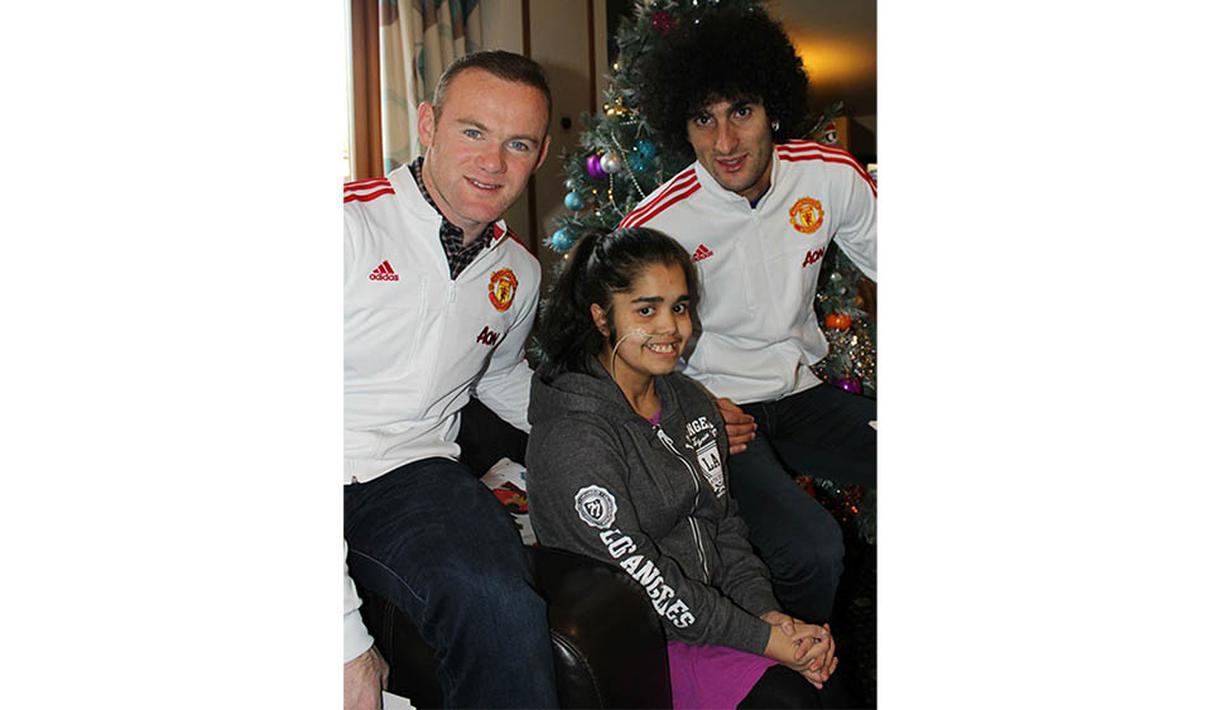 Kapten Manchester United, Wayne Rooney dan Marouane Fellaini, foto bersama seorang anak yang sedang menjalani pengobatan di Francis House. (www.manutd.com)