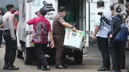 Petugas membawa barang bukti kasus pembunuhan berencana Brigadir J saat proses pelimpahan tahap dua kasus tersebut di Gedung Kejaksaan Agung, Jakarta, Rabu (5/10/2022). Penyidik Bareskrim Polri menyerahkan barang bukti beserta kesebelas tersangka kepada Kejaksaan Agung terkait kasus pembunuhan berencana Brigadir J dan obstruction of justice yang menjerat mantan Kadiv Propam Ferdy Sambo sebagai tersangka. (Liputan6.com/Herman Zakharia)