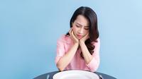 Potret seorang perempuan menahan lapar setelah mengonsumsi makanan dietnya. (Foto dok: Freepik/timeimage).
