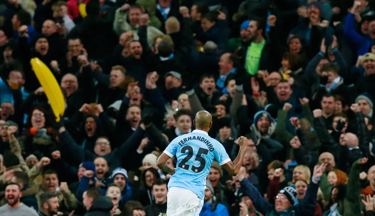 Penonton membawa sebuah balon pisang (kiri) saat gelandang Manchester City, Fernandinho merayakan gol di stadion Etihad, Inggris, (27/1). Balon pisang dilempar oleh salah satu penonton kedalam lapangan. (Reuters / Andrew Yates)