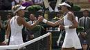 Garbine Muguruza (kanan) bersalaman dengan Angelique Kerber usai laga hari ketujuh tunggal putri di Wimbledon Tennis Championships, London, (10/7/2017). Garbine menang 4-6, 6-4, 6-4. (AP/Tim Ireland)