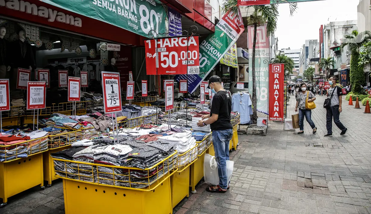 Pengunjung melihat pakaian yang dijajakan di salah satu tenant di Pasar Baru, Jakarta, Rabu (5/4/2021). Selama pandemi COVID-19, tak banyak orang yang mau berbelanja di luar rumah. (Liputan6.com/Faizal Fanani)