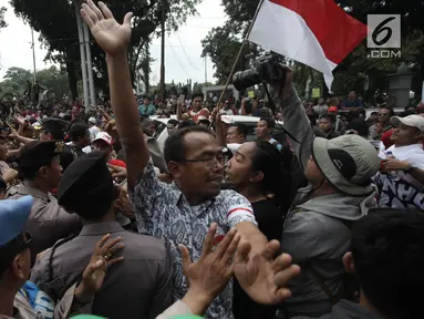 Demonstran driver online saling dorong dengan pihak kepolisian saat unjuk rasa di depan Istana Negara, Jakarta, Rabu (14/2). Kericuhan nyaris terjadi lantaran demonstran mencegat para driver online yang masih beroperasi. (Liputan6.com/Arya Manggala)