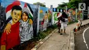 Warga melintas di depan mural solidaritas untuk Palestina di Jalan Juanda, Depok, Jawa Barat, Rabu (8/11/2023). Mural tersebut ditujukan sebagai bentuk solidaritas dan dukungan kepada warga Gaza Palestina atas serangan pasukan Israel. (merdeka.com/Arie Basuki)