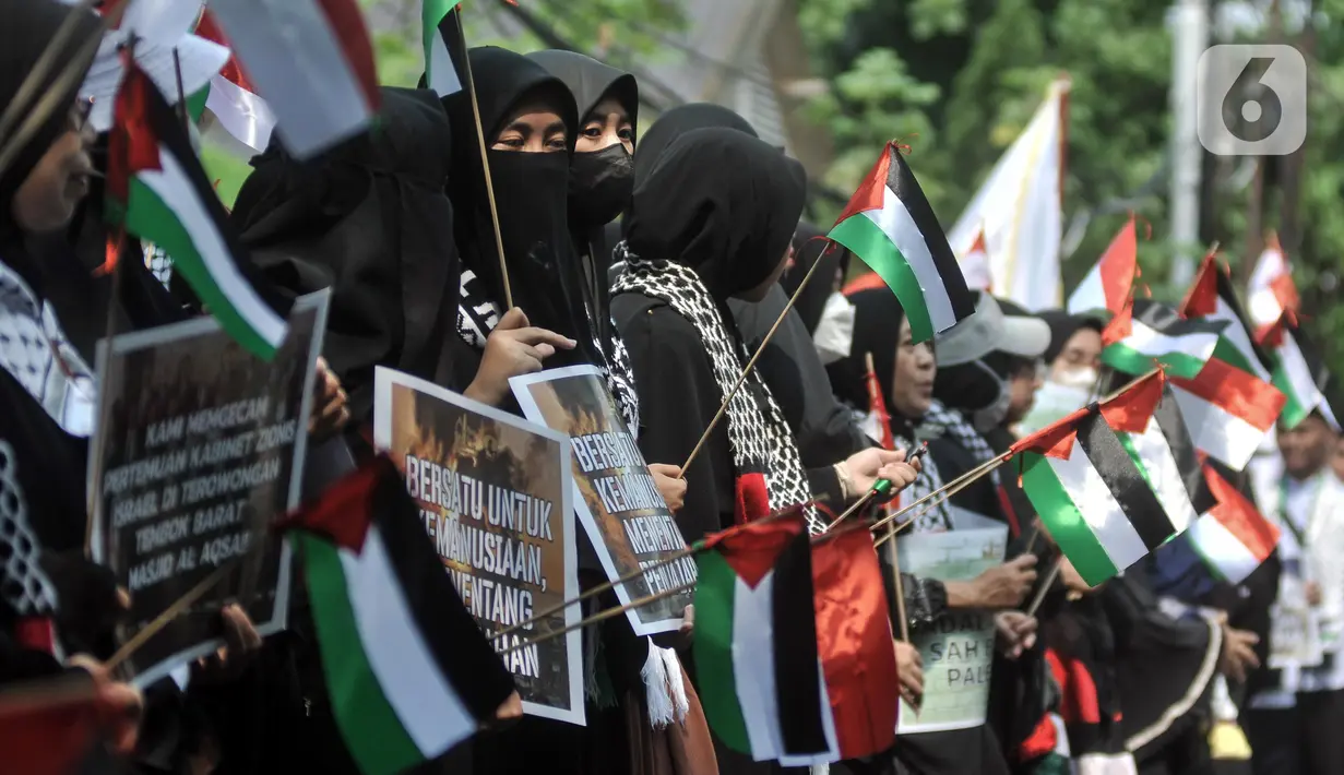 Massa yang tergabung dalam Aqsa Working Group (AWG) membentangkan poster dan bendera Palestina serta Indonesia saat menggelar Aksi Damai Solidaritas untuk Palestina di Kantor Kedutaan Besar Palestina untuk Indonesia. (merdeka.com/Iqbal S. Nugroho)