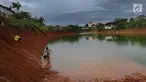 Anak-anak memancing pada bagian proyek pembangunan tol Cinere-Serpong yang berubah menjadi danau sedalam 4 meter di kawasan Cipayung, Tangsel, Banten (17/1). Pembangunan jalan Tol ini sepanjang 10,14 kilometer. (Merdeka.com/Arie Basuki)