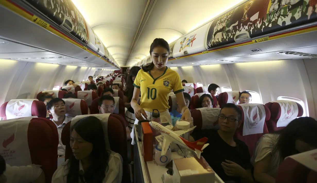 Dalam rangka memeriahkan ajang Piala Dunia 2014, para pramugari mengenakan kaos bola Brazil dalam penerbangan ke Hangzhou, Yunnan, China, Senin (23/6/14). (REUTERS/Wong Campion)