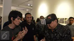 Menteri Koperasi dan UKM, AAGN Puspayoga mencoba virtual box (VRbox) usai meresmikan pembukaan Anugerah Pewarta Foto Indonesia (APFI) 2017 di Jakarta, Jumat (21/4). (Liputan6.com/Faizal Fanani)