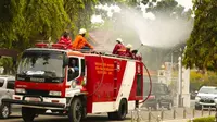 Petugas Pemadam Kebakaran Kota Pekanbaru menyemprotkan cairan disinfektan untuk mencegah penyebaran virus corona. (Liputan6.com/Hms Pemko Pekanbaru/M Syukur)