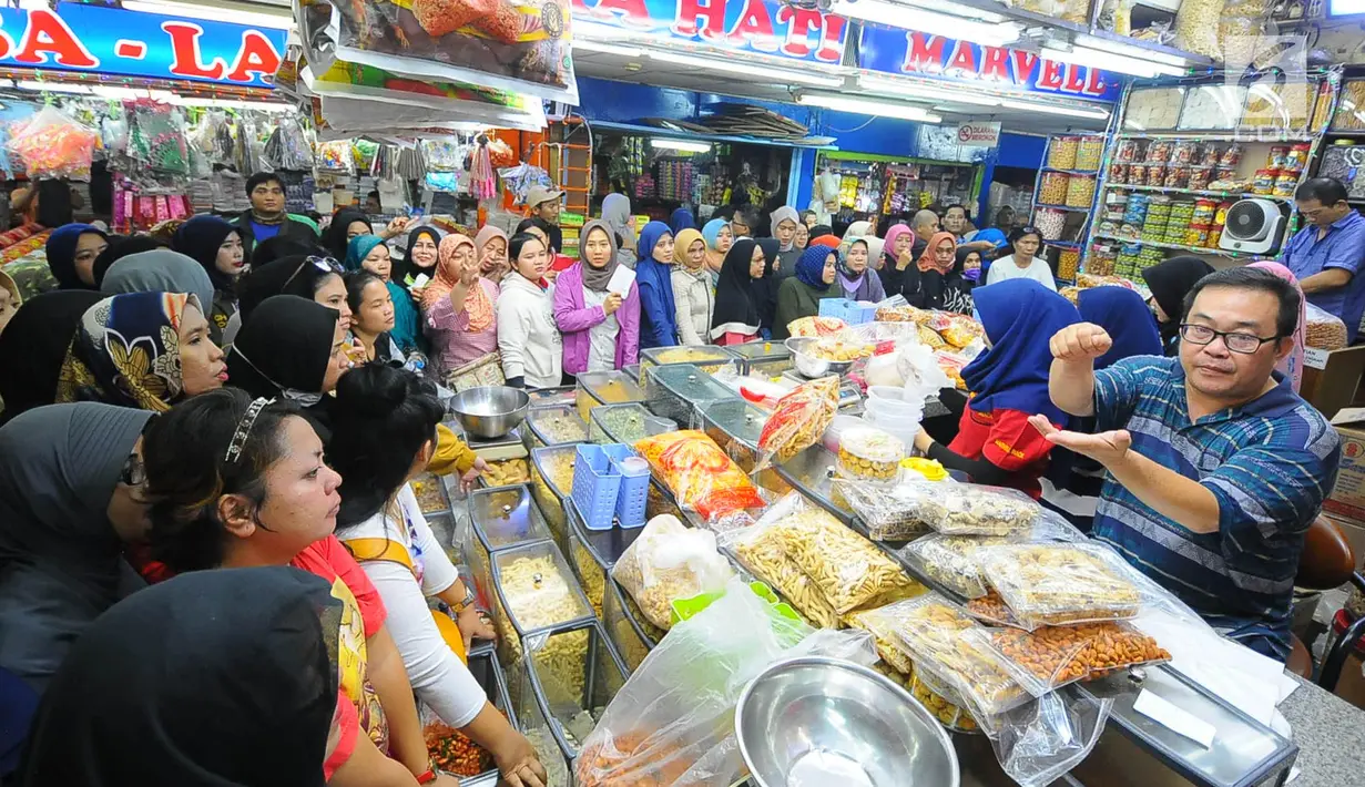Pedagang kue kering melayani pembeli di Pasar Jatinegara, Jakarta, Senin (27/5/2019). Jelang Idul Fitri 2019, banyak warga berburu makanan ringan seperti kue kering untuk jamuan di hari raya. (Liputan6.com/Angga Yuniar)