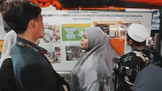Keluarga santri memeriksa papan informasi sambil menunggu upaya penyelamatan bagi korban yang terjebak reruntuhan bangunan yang sedang dibangun di sebuah pondok pesantren di Sidoarjo, Jawa Timur, Rabu 1 Oktober 2025. (AP Photo/Achmad Ibrahim)