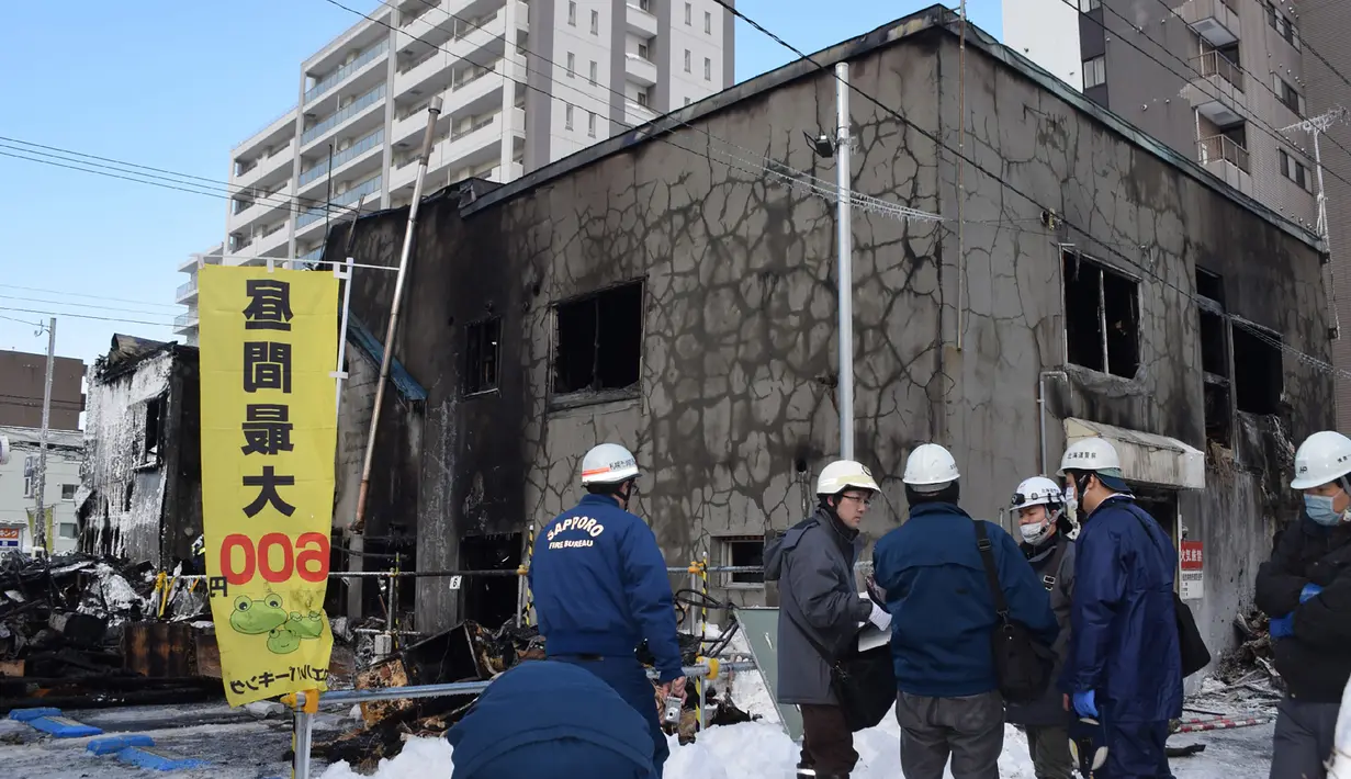 Petugas kepolisian memeriksa kondisi panti jompo yang hangus terbakar di Sapporo, utara Jepang, Kamis (1/2). Sebelumnya, pada Maret 2010, di wilayah yang sama, kebakaran juga melanda rumah bagi kaum lansia yang menderita demensia. (JIJI PRESS / AFP)