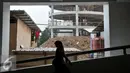 Warga melintas di depan lokasi pembangunan Blok III Pasar Senen, Jakarta, Kamis (20/10). Blok III Pasar Senen nantinya akan digunakan bagi para pedagang yang menjadi korban kebakaran hebat pada 25 April 2014 lalu. (Liputan6.com/Yoppy Renato)