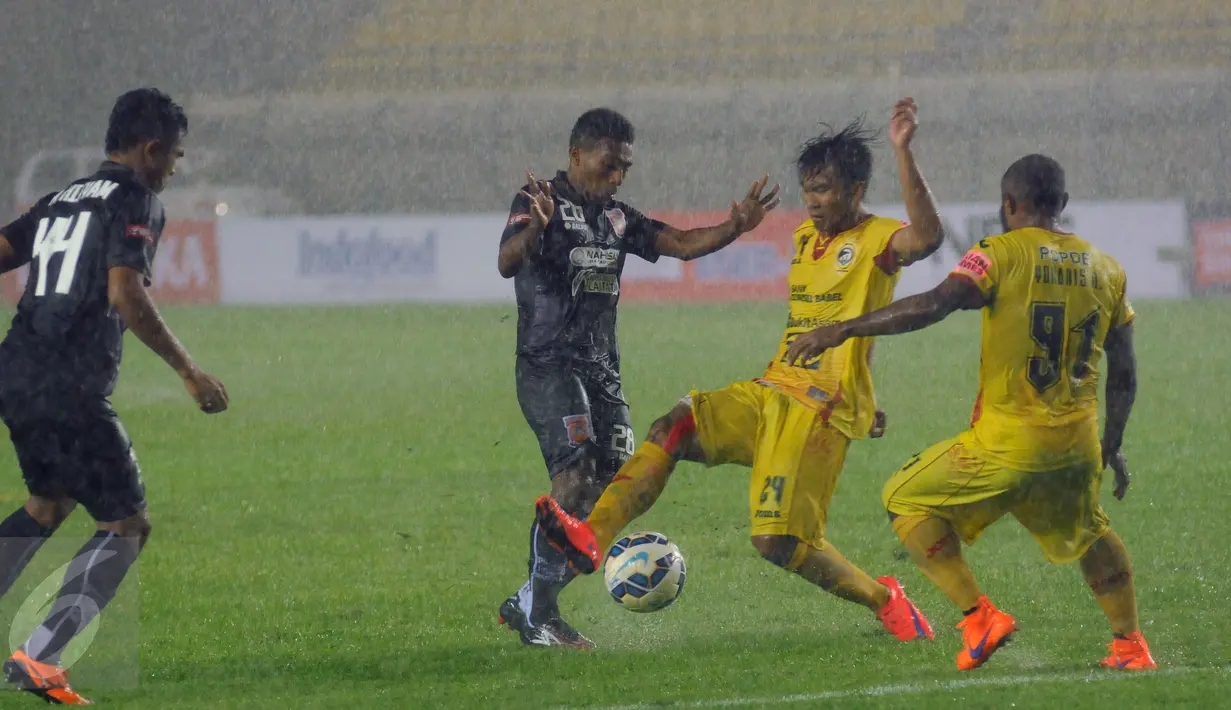 Pemain Sriwijaya FC dan PBFC berebut bola ditengah hujan deras saat berlaga di turnamen Piala Bhayangkara di Stadion Si Jalak Harupat, Bandung, Jumat (18/3/2016). Sriwijaya unggul 3-1 atas PBFC. (Liputan6.com/Helmi Fithriansyah)