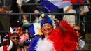 Seorang fans Prancis mengenakan kostum ayam mengibarkan bendera negaranya sebelum pertandingan Rugby World Cup Pool C antara Prancis dan Tonga di Stadion Kumamoto di Kumamoto (6/10/2019). (AFP Photo/Gabriel Bouys)