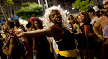 Seorang wanita menari saat merayakan karnaval "Maria vem com as outras" di Rio de Janeiro, Brasil (3/2). Karnaval ini digelar agar mendorong wanita di Brasil melaporkan pelecehan jika terjadi pada mereka. (AP Photo / Silvia Izquierdo)