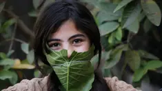 Seorang anak berpose dengan masker yang terbuat dari kubis saat dihibur oleh ibu mereka selama pandemi corona (Covid-19) di Beit Lahia di Jalur Gaza utara (16/4/2020). (AFP/Mohamed Abed)